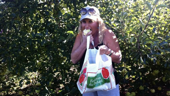 Марта Литас, основатель Центра, собирает яблоки осенью на природе Фото: Л. Литас