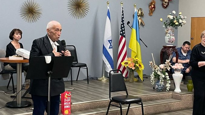 95-летний участник Центра Forever Young Давид Берин произносит слова поддержки и надежды в память о трагедии 11 сентября. На сцене рядом — Любовь Бел, директор культурно-просветительных программ, и музыкальный руководитель Диана Кофман. Фото: Л. Бел